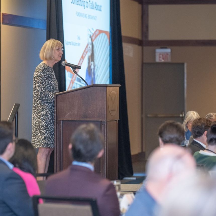 Mary Monnat, CEO and President of LifeWorks NW, presents at the organization's 2025 Something to Talk About fundraiser breakfast.