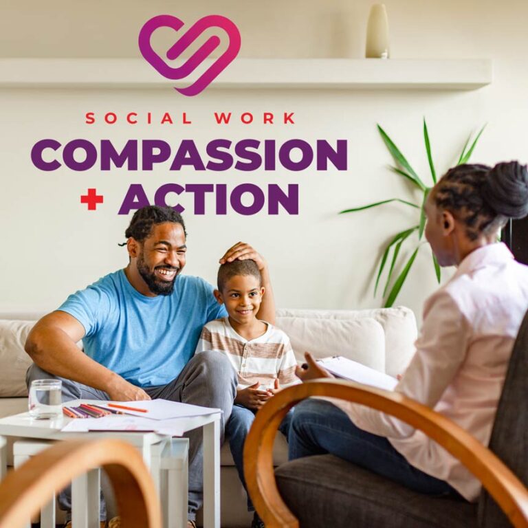 A father and child sit on a couch smiling while listening to a social worker in a chair nearby.